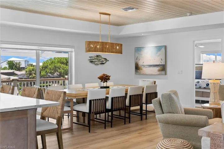 Open-concept dining area featuring wood-finish flooring and a wood-paneled ceiling