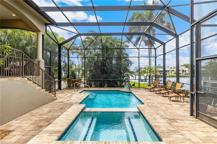 View of pool with a patio, a water view, and a lanai