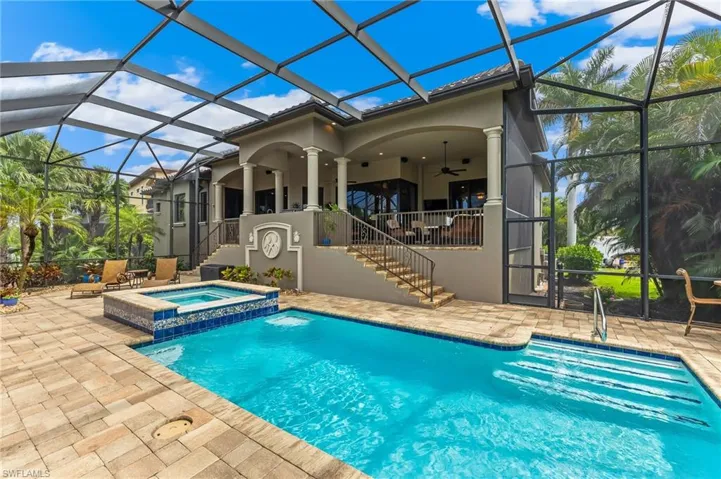 View of pool featuring stairway, a patio, a sunroom, and a pool with connected hot tub