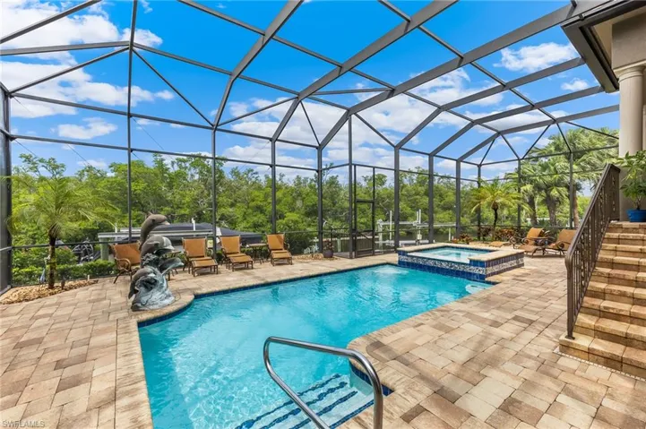 View of pool with a sunroom, a patio, a pool with connected hot tub, and glass enclosure