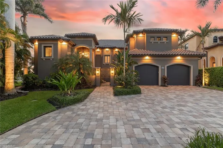Mediterranean / spanish house featuring decorative driveway, a gate, stucco siding, a garage, and a tiled roof