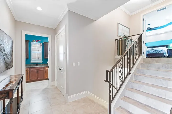 Staircase with crown molding and tile patterned flooring