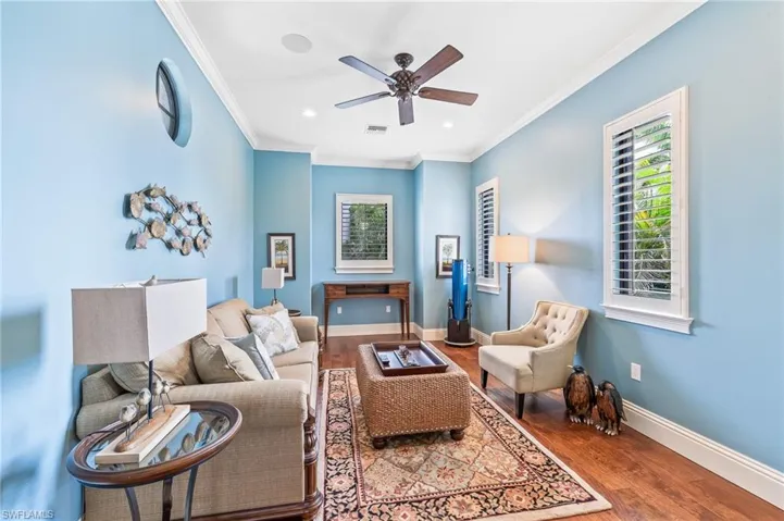 Living room with ornamental molding, plenty of natural light, wood finished floors, a ceiling fan, and recessed lighting