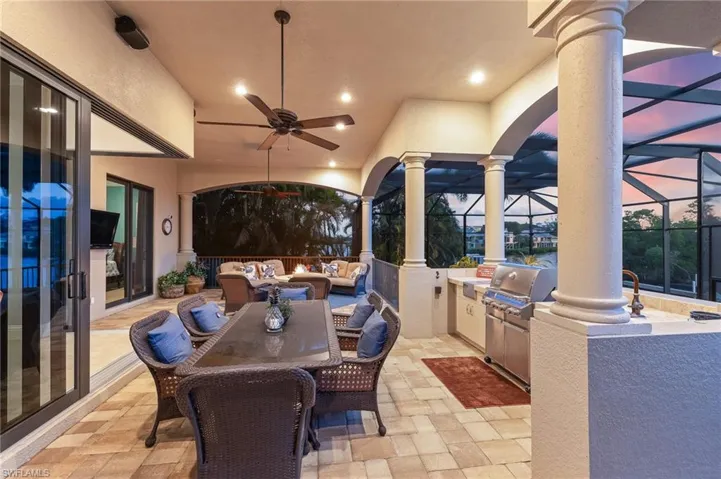 View of patio / terrace with an outdoor kitchen, an outdoor hangout area, outdoor dining space, a lanai, and ceiling fan
