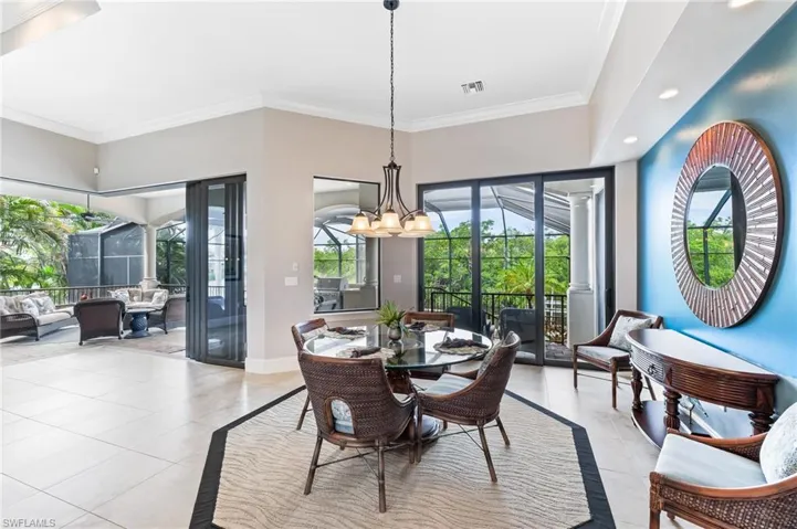 Dining area with ornamental molding, a chandelier, light tile patterned flooring, and recessed lighting