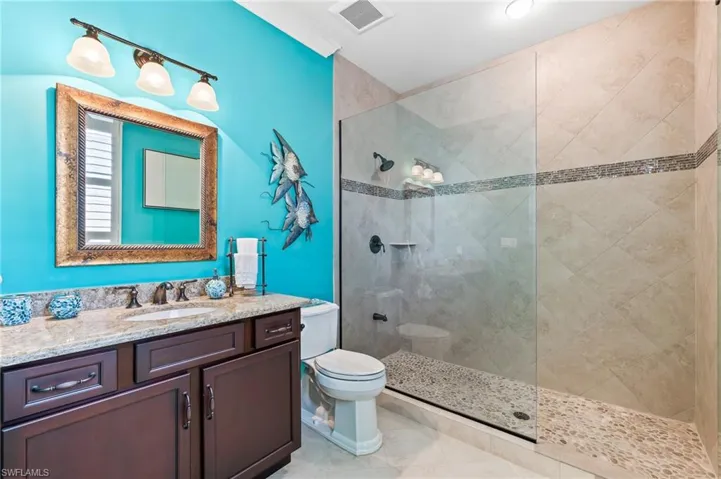Bathroom with vanity, walk in shower, and light tile patterned flooring