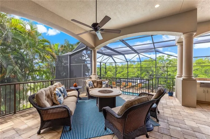 View of patio / terrace with glass enclosure, an outdoor living space with a fire pit, a sunroom, a ceiling fan, and area for grilling