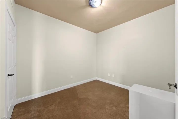 Spare room featuring dark carpet