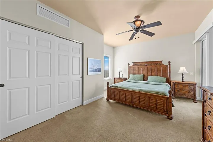 Carpeted bedroom featuring a closet and ceiling fan