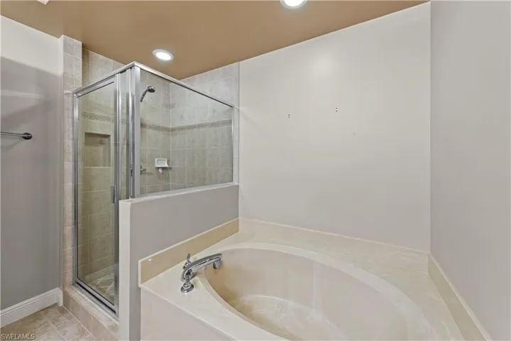 Bathroom with tile flooring and separate shower and tub