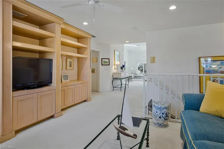Living room with ceiling fan, light colored carpet, and recessed lighting