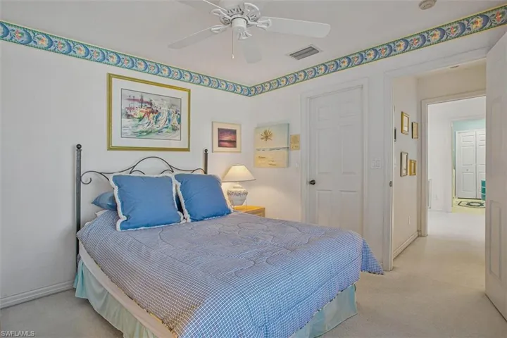 Carpeted bedroom with a ceiling fan