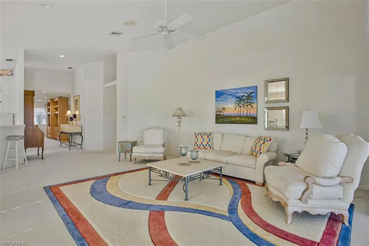 Carpeted living area with a ceiling fan and recessed lighting