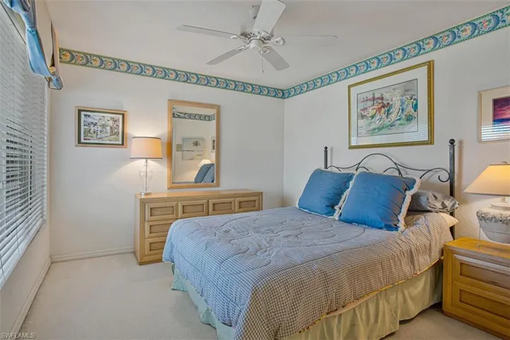 Carpeted bedroom featuring a ceiling fan and baseboards