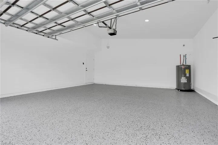 Garage featuring water heater and baseboards