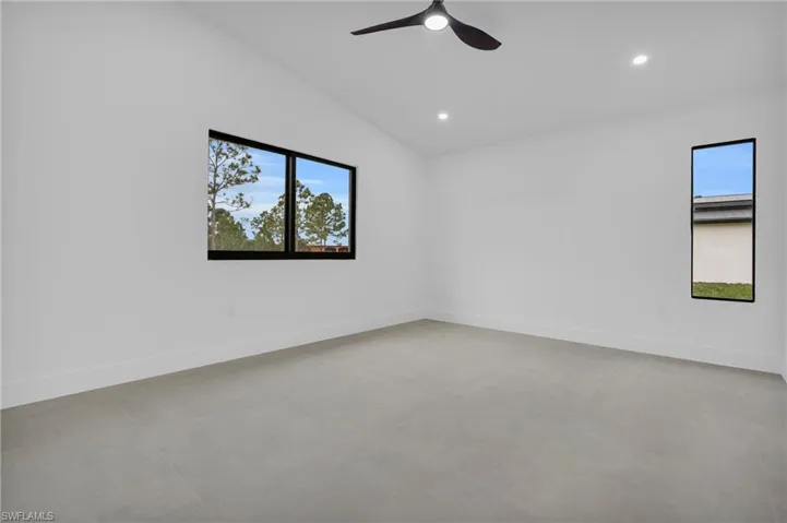 Unfurnished room featuring vaulted ceiling, recessed lighting, concrete floors, and a ceiling fan