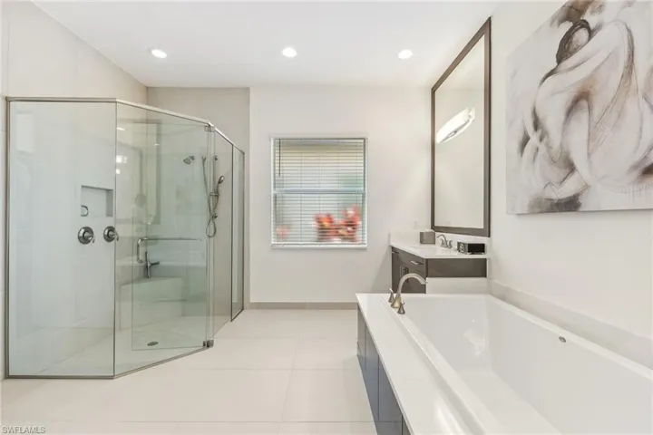 Primary bathroom featuring dual sinks separate soaking tub and shower