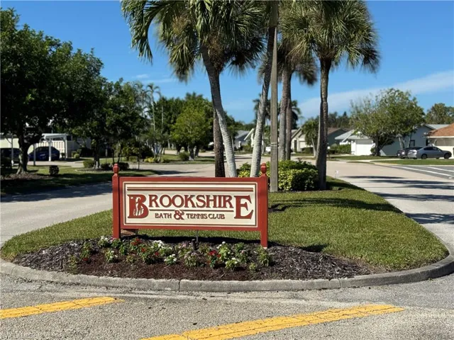 Community sign featuring a residential view and a yard