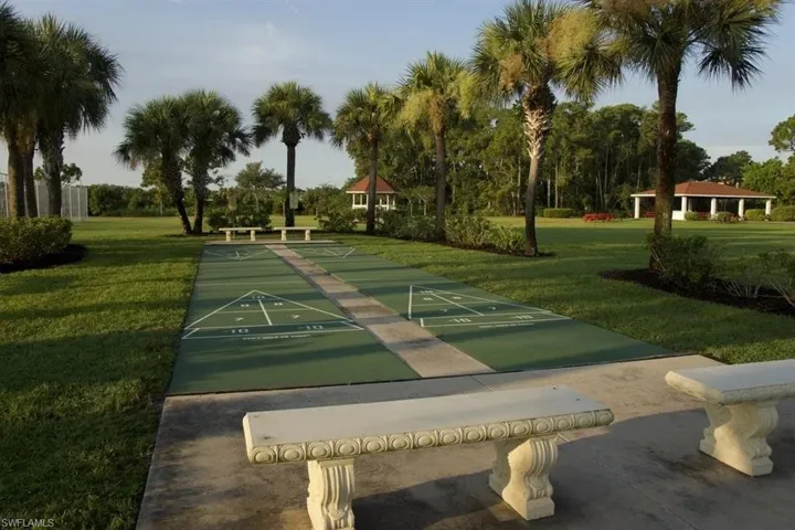 View of property's community with shuffleboard and a yard