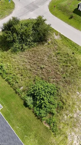 Expansive land parcel with surrounding paved roads, and lush green areas