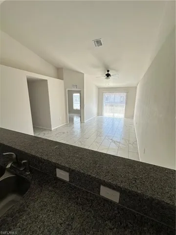 Empty room featuring a ceiling fan and light marble finish floors