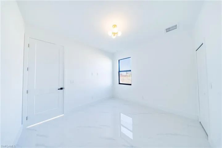 Spare room featuring light marble finish flooring