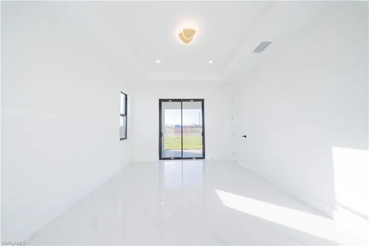 Unfurnished room with light marble finish flooring, recessed lighting, and a raised ceiling