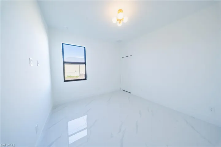 Unfurnished room with baseboards and light marble finish flooring
