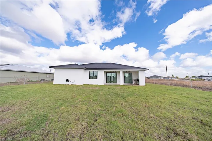 Rear view of property featuring stucco siding and a patio area