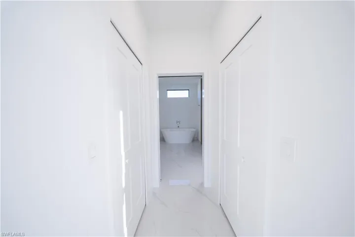 Corridor featuring light marble finish flooring