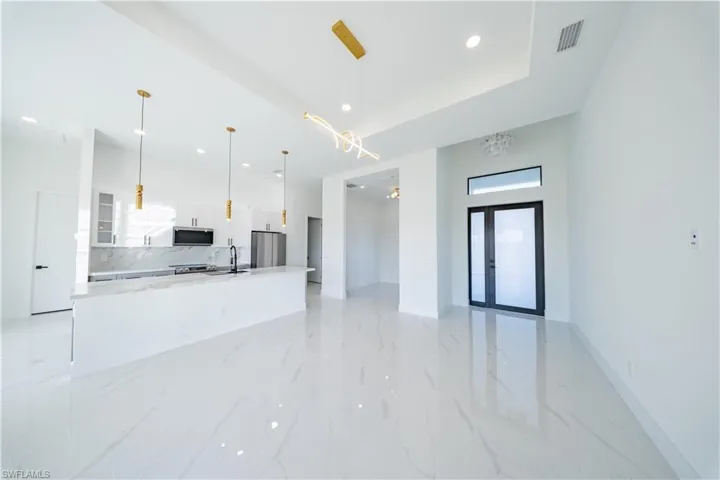 Unfurnished living room featuring recessed lighting and french doors