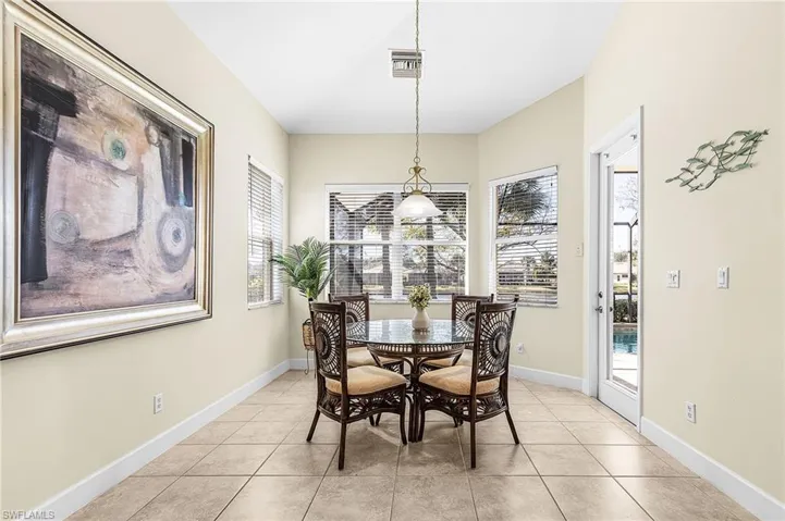 large dining area off of kitchen overlooking pool