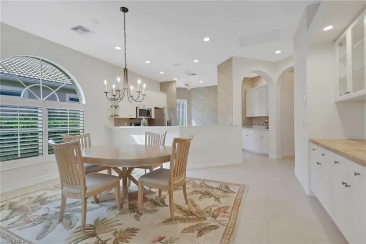 Dining room with recessed lighting, a chandelier, and arched walkways