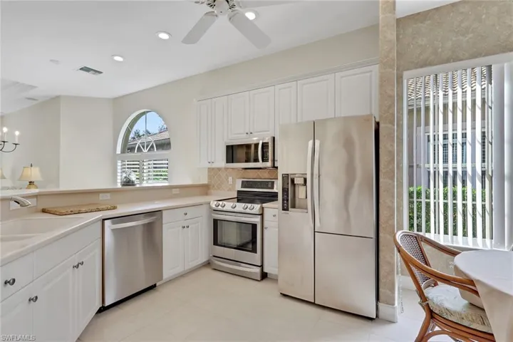 Kitchen featuring stainless steel appliances, white cabinetry, light countertops, recessed lighting, and ceiling fan