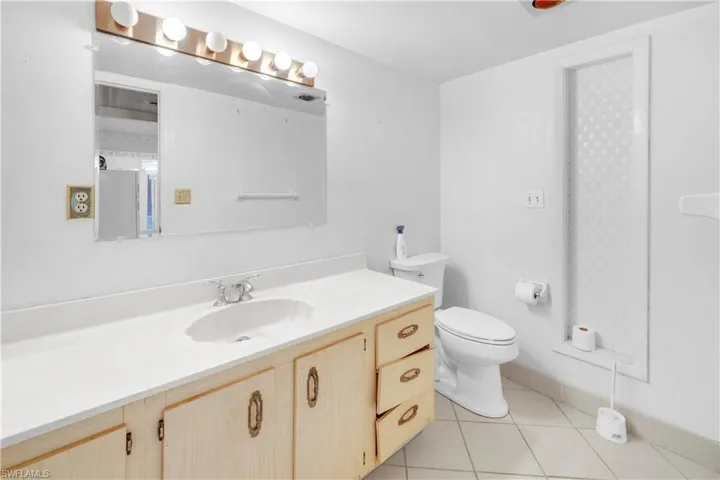 Bathroom with tile flooring, vanity, and toilet