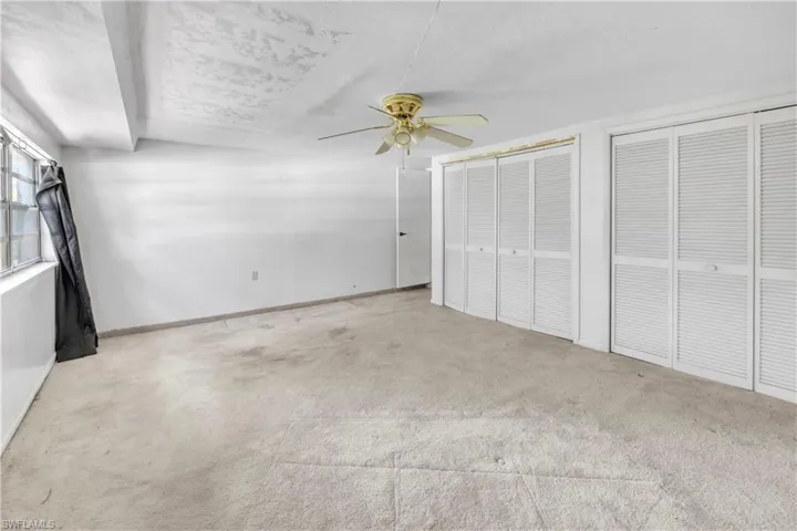 Unfurnished bedroom with multiple closets, carpet, and ceiling fan