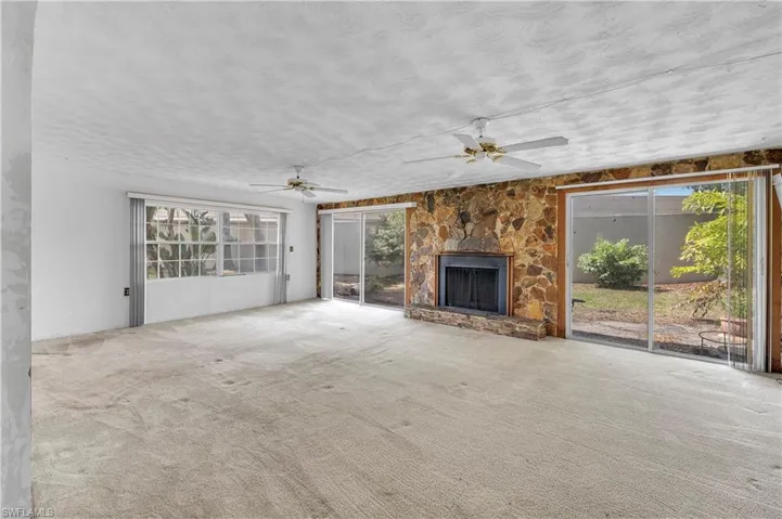 Unfurnished living room with carpet flooring and plenty of natural light