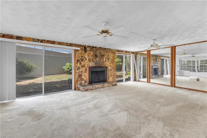 living room featuring a fireplace, carpet, and ceiling fan