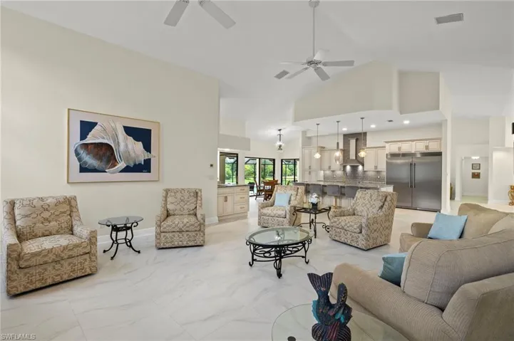 Living area featuring marble finish floor, high vaulted ceiling, ceiling fan, and visible vents