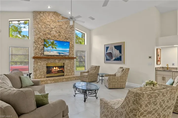 Living area featuring high vaulted ceiling, a wealth of natural light, and a ceiling fan