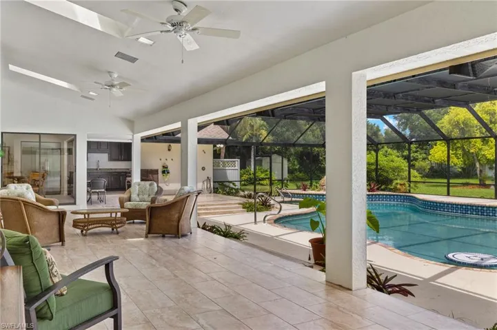 Pool featuring a lanai, a patio, an outdoor living space, and ceiling fan