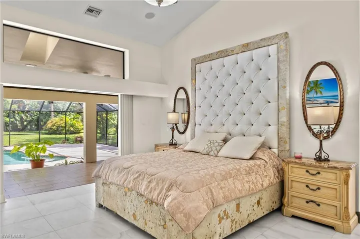 Bedroom featuring high vaulted ceiling, visible vents, and access to exterior