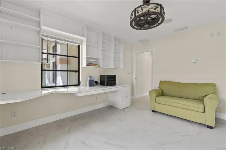 Office featuring marble finish floor, baseboards, built in study area, and visible vents