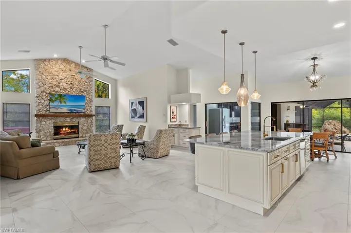 Kitchen featuring high vaulted ceiling, freestanding refrigerator, cream cabinetry, a sink, and open floor plan