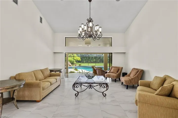 Living area with a chandelier, visible vents, and marble finish floor
