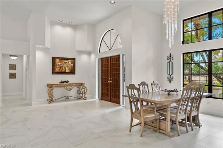 Dining area with a wealth of natural light, a high ceiling, and baseboards