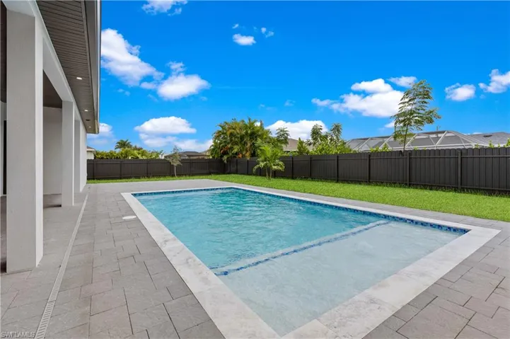 View of swimming pool with a patio area and a yard