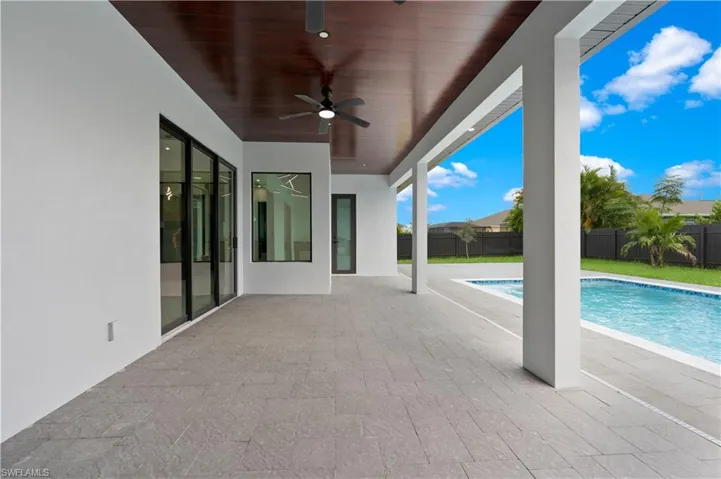 View of patio with a fenced in pool and ceiling fan