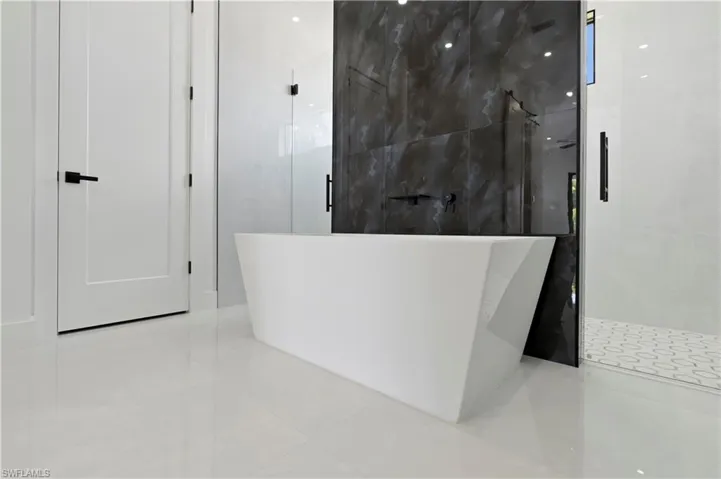 Bathroom with independent shower and bath and tile patterned floors