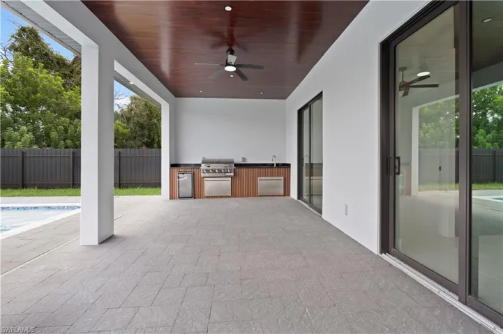 View of patio with a fenced in pool, grilling area, area for grilling, and ceiling fan